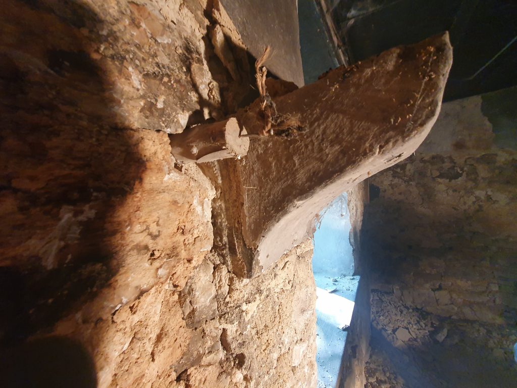 Ancien morceau de bois permettant de clouer plinthe ou objets décoratifs dans un mur en pierre 