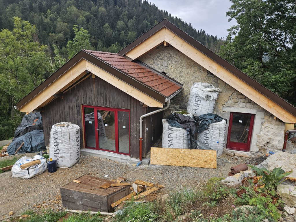 Pose de fenêtres triple vitrage bois aluminium rouge sur ferme en pierres