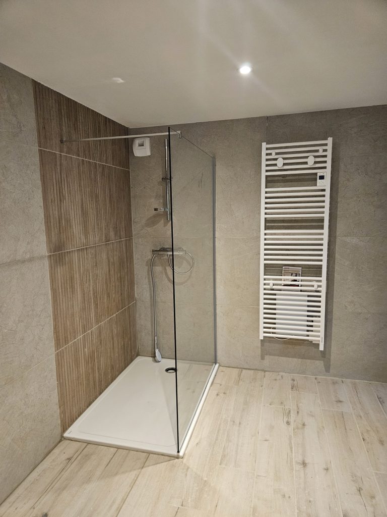 Salle de douche italienne et grands carreaux de carrelage modernes et sèche serviette