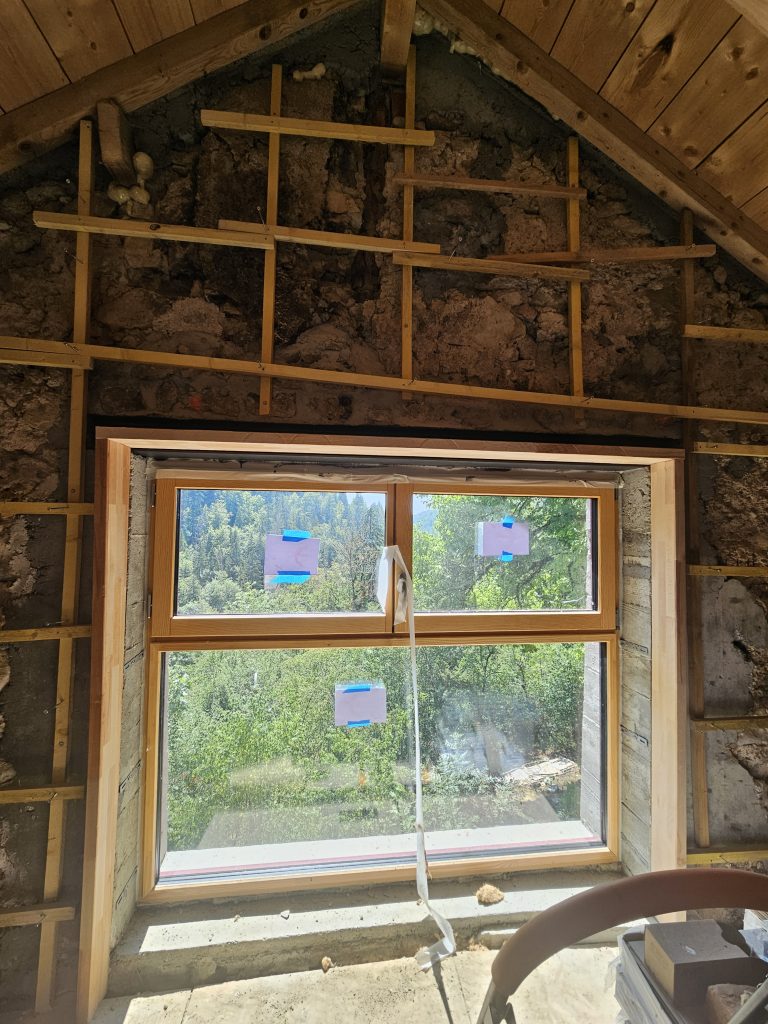 ossature bois en tasseau sur mur en pierres pour la pose du chaux chanvre banché